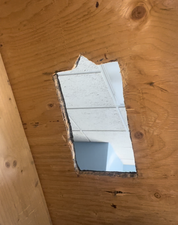 Wooden panel with a rectangular cutout revealing a blue sky
