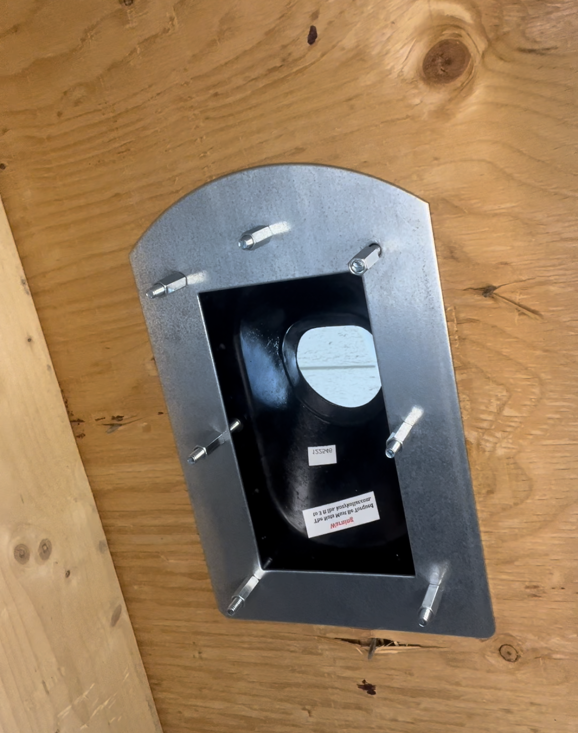 Metal bracket with a circular component on a wooden surface